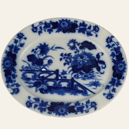 A large oval ceramic platter with a blue Yedo pattern featuring floral designs and a stylized Eastern landscape. - Authentic antique piece 