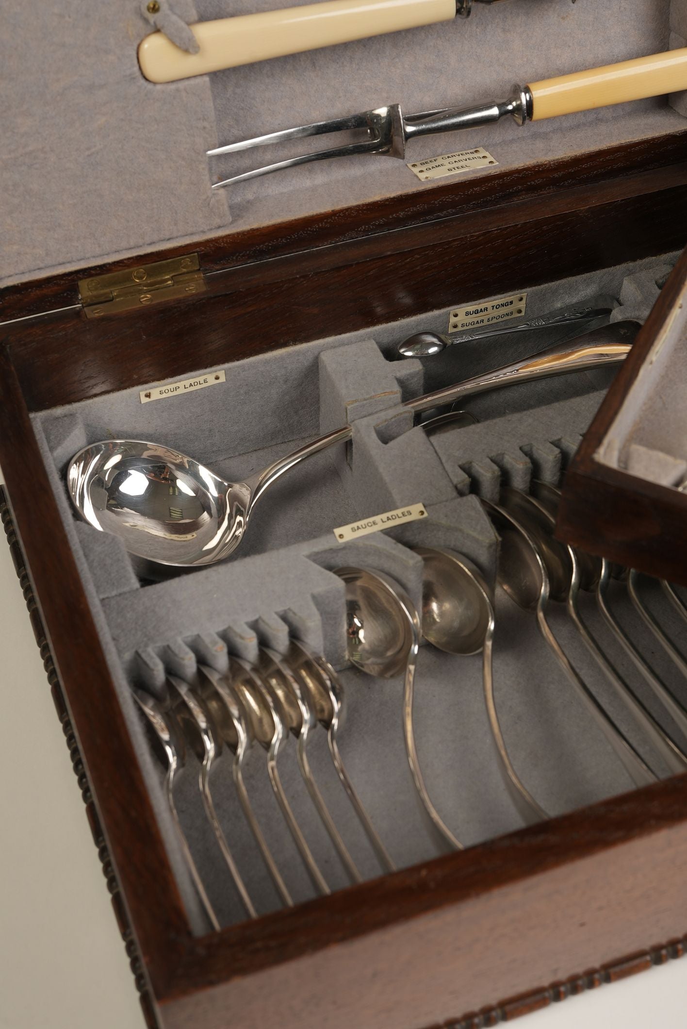 Set of silverware in a wooden case with gray interior