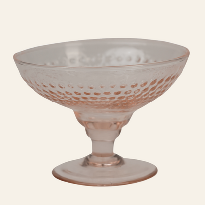 A blush pink handcrafted dessert bowl with a geometric bubble-pattern texture, featuring a refined pedestal base.