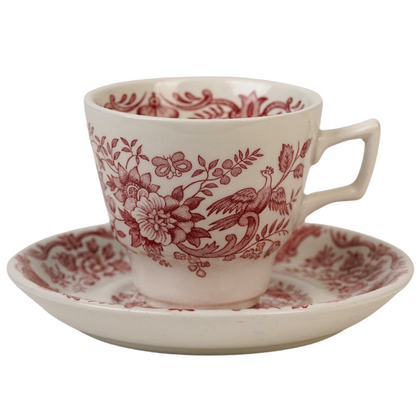 A vintage espresso cup with a floral red and white pattern on a matching saucer.