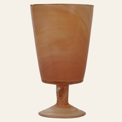 A handcrafted marbled glass goblet with a beige base and a swirling marbled pattern.