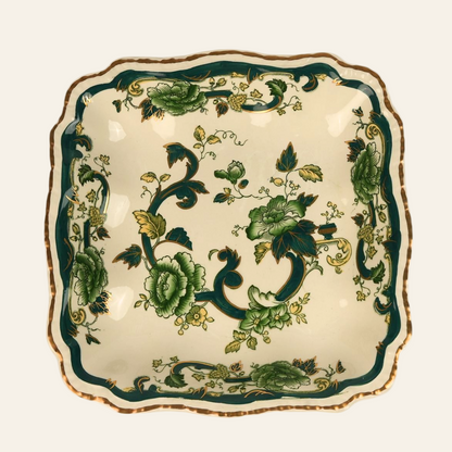 A square ceramic serving platter with a green and gold floral pattern and a scalloped edge. - Authentic antique piece 