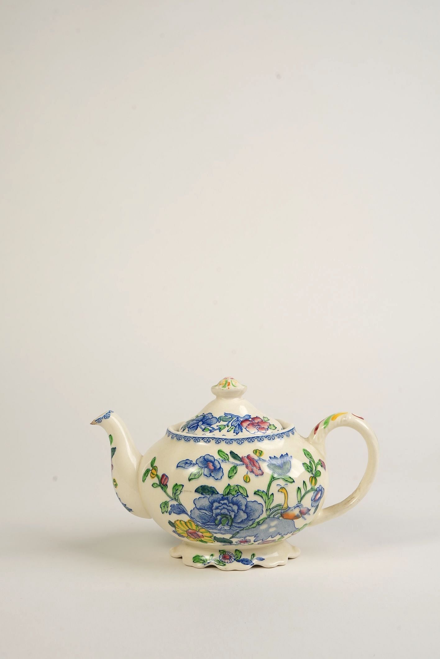 Decorative vintage teapot with floral patterns on a white background