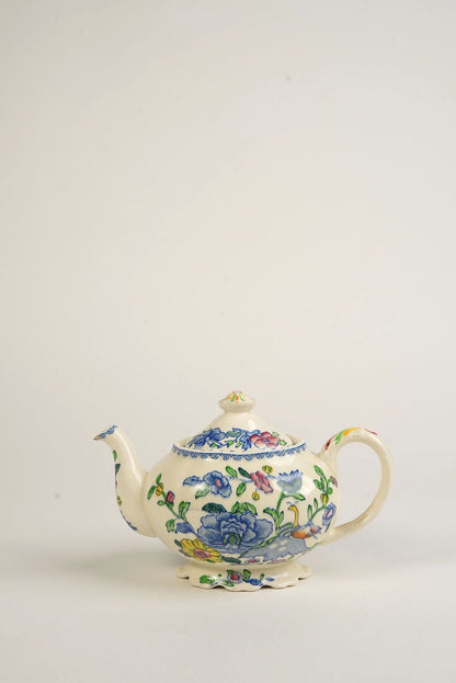 Decorative vintage teapot with floral patterns on a white background