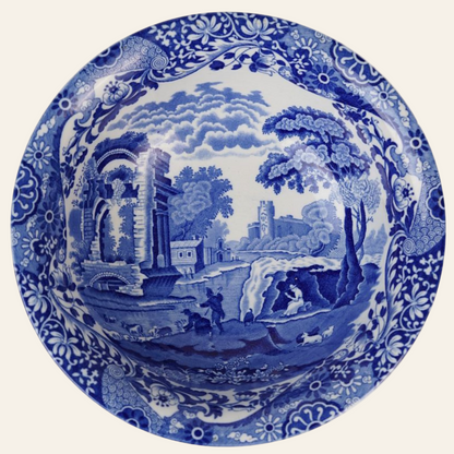 A large blue and white Spode ceramic bowl with a pastoral scene that includes trees, a building, and a river.