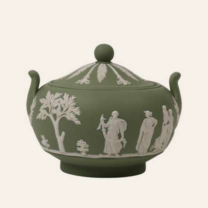 A vintage green Wedgwood pot with white classical figure reliefs and a lid.