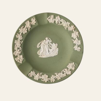 A vintage green Wedgwood ceramic ashtray with a classical scene and ornate border in white.