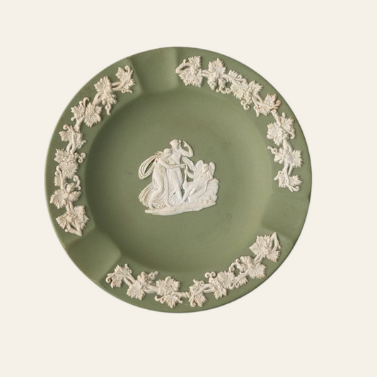 A vintage green Wedgwood ceramic ashtray with a classical scene and ornate border in white.