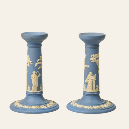 Two blue candlesticks with decorative white figures on a white background