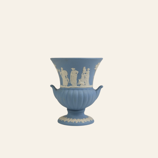 Blue ceramic urn with white relief decoration on a white background