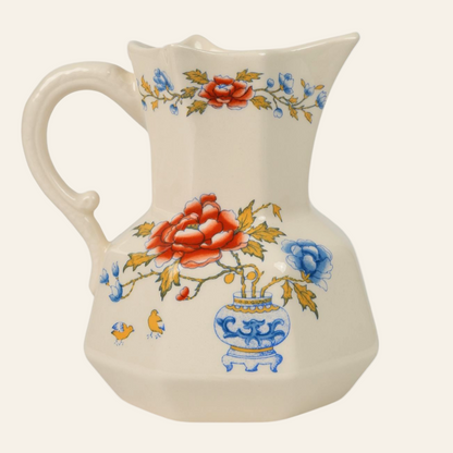 A ceramic creamer jug with a floral pattern featuring blues, reds, and yellows, indicative of the Ironstone Regency design.