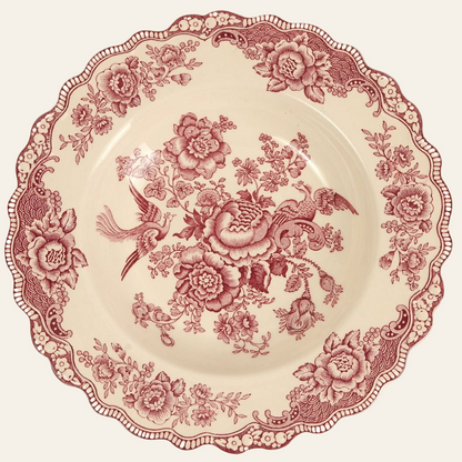 A vintage Crown Ducal Bristol Pink transferware soup plate with a scalloped rim and a floral pattern in rose-pink tones on a warm ivory base.