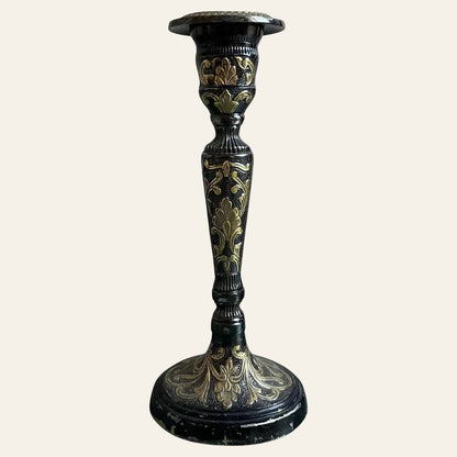Decorative black and gold candlestick on a white background