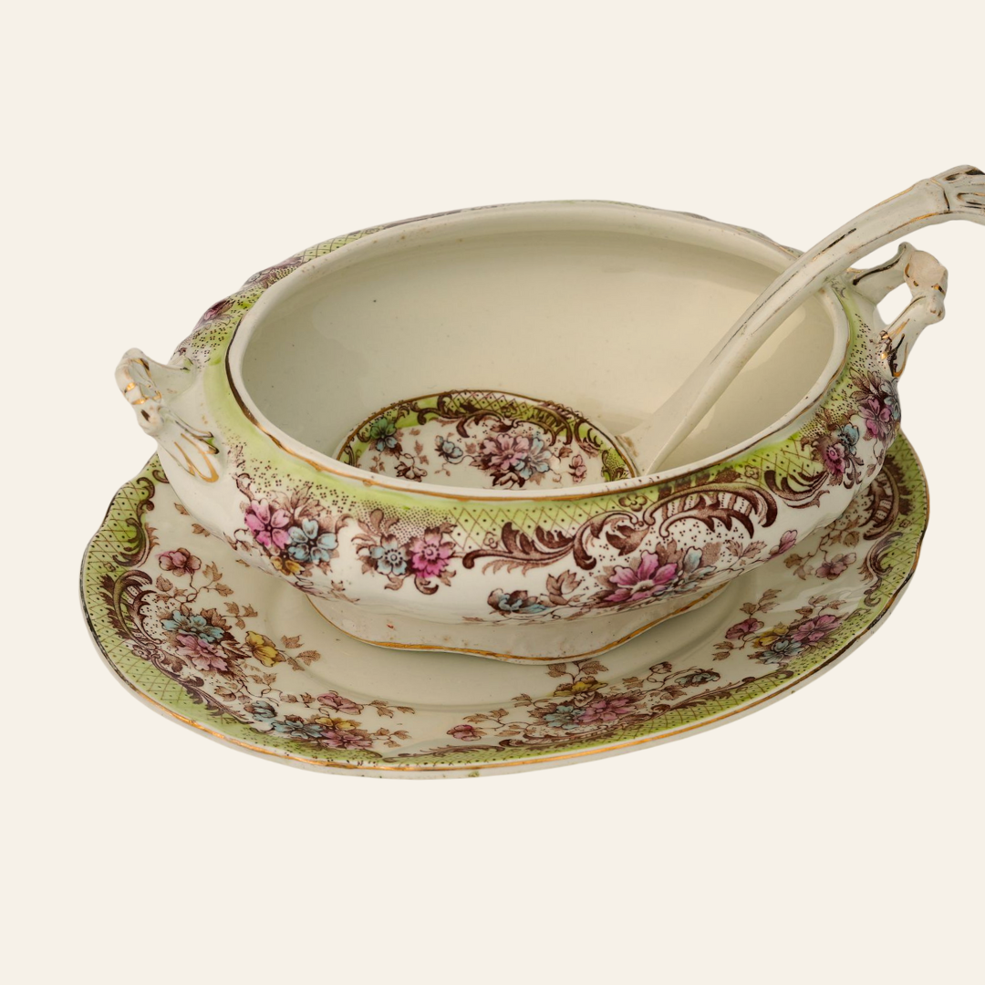 Decorative vintage ceramic soup tureen with floral patterns on a white background