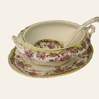 Decorative vintage ceramic soup tureen with floral patterns on a white background