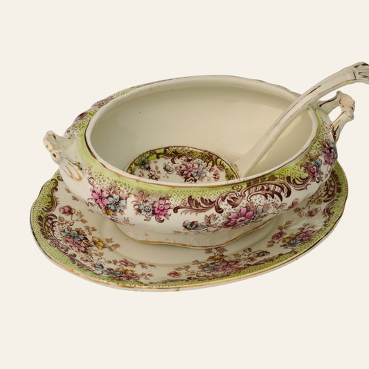 Decorative vintage ceramic soup tureen with floral patterns on a white background